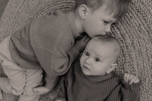 big brother kissing baby sibling