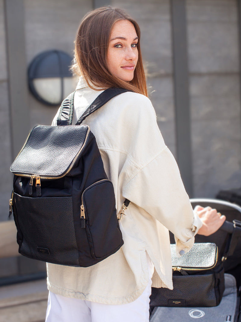 Storksak Alyssa | Black convertible diaper changing Bag with Gold Zips | mum carrying bag as backpack and pushing pram