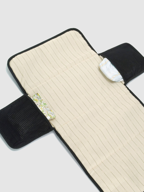 Storksak Travel eco baby changing mat, open view with nappies and wipes in pockets
