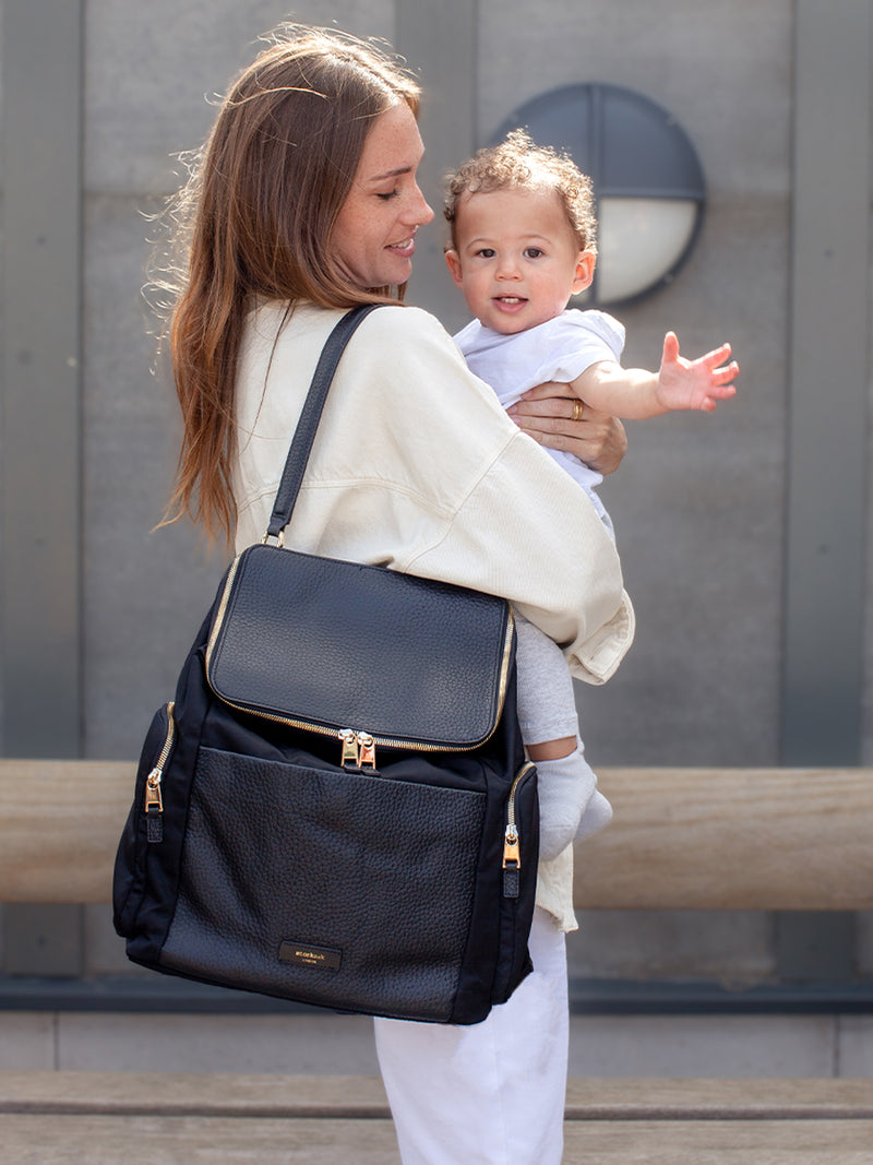 Storksak Alyssa | Black convertible diaper changing Bag with Gold Zips | mum with baby carrying bag as shoulder bag