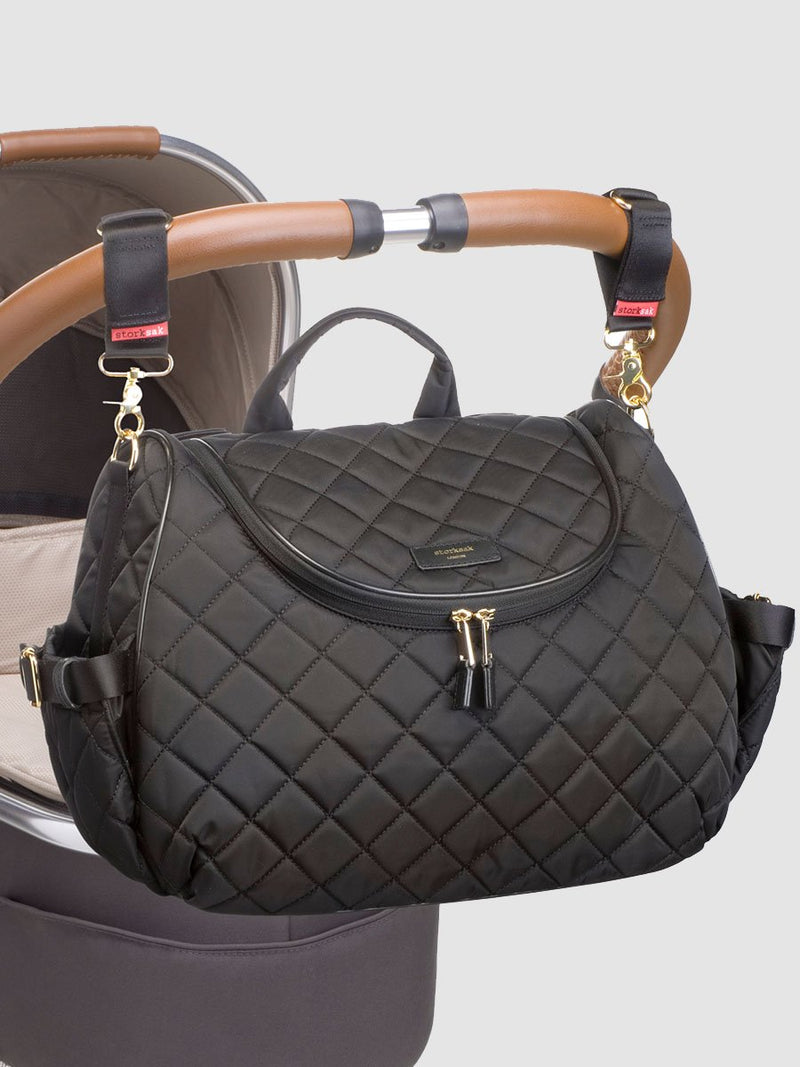 storksak poppy quilt black, convertible changing bag, attached to pram with stroller clips